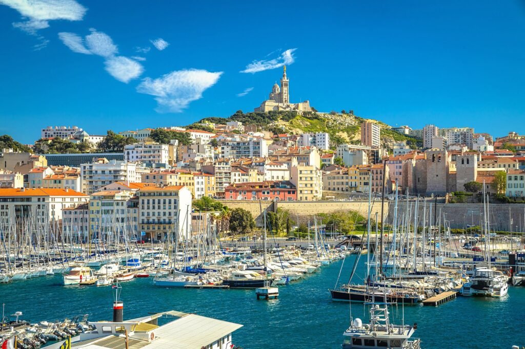 Vue du Vieux-Port de Marseille avec la basilique Notre-Dame de la Garde en fond, symbole emblématique de la ville